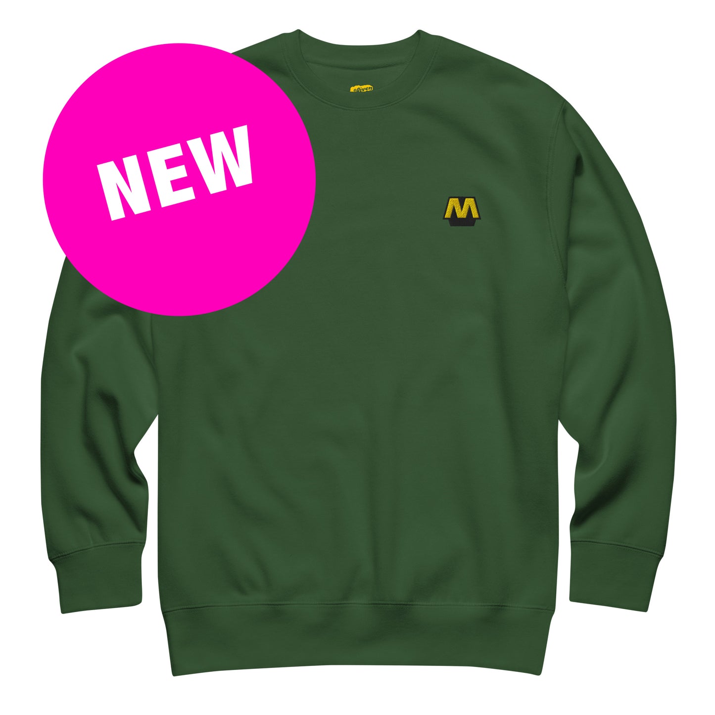 Groene trui met het Metro logo geborduurd op de borst, ontwerp door De Zwarte Markt en verkrijgbaar bij cadeauwinkel 'A Given Horse'. Voorkant, nieuw.